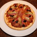 Pizza met salami, artisjokken en olijven